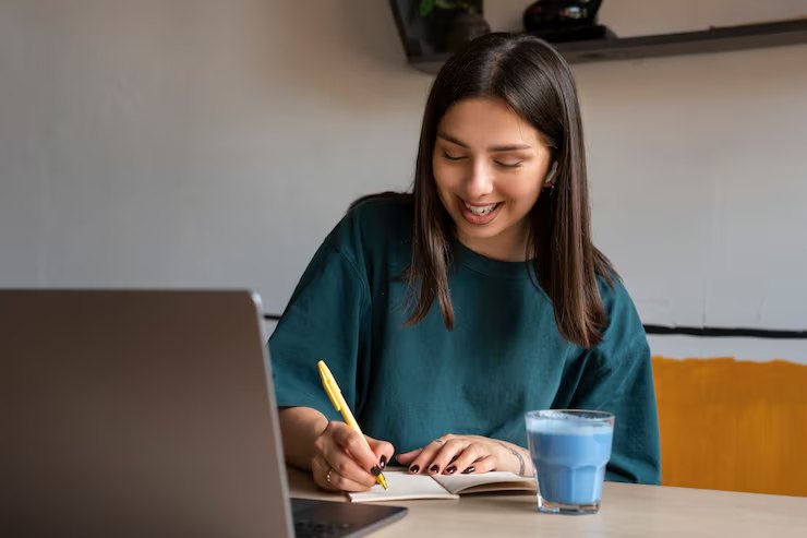 Alumna estudiando neerlandés con su cuaderno y el portátil